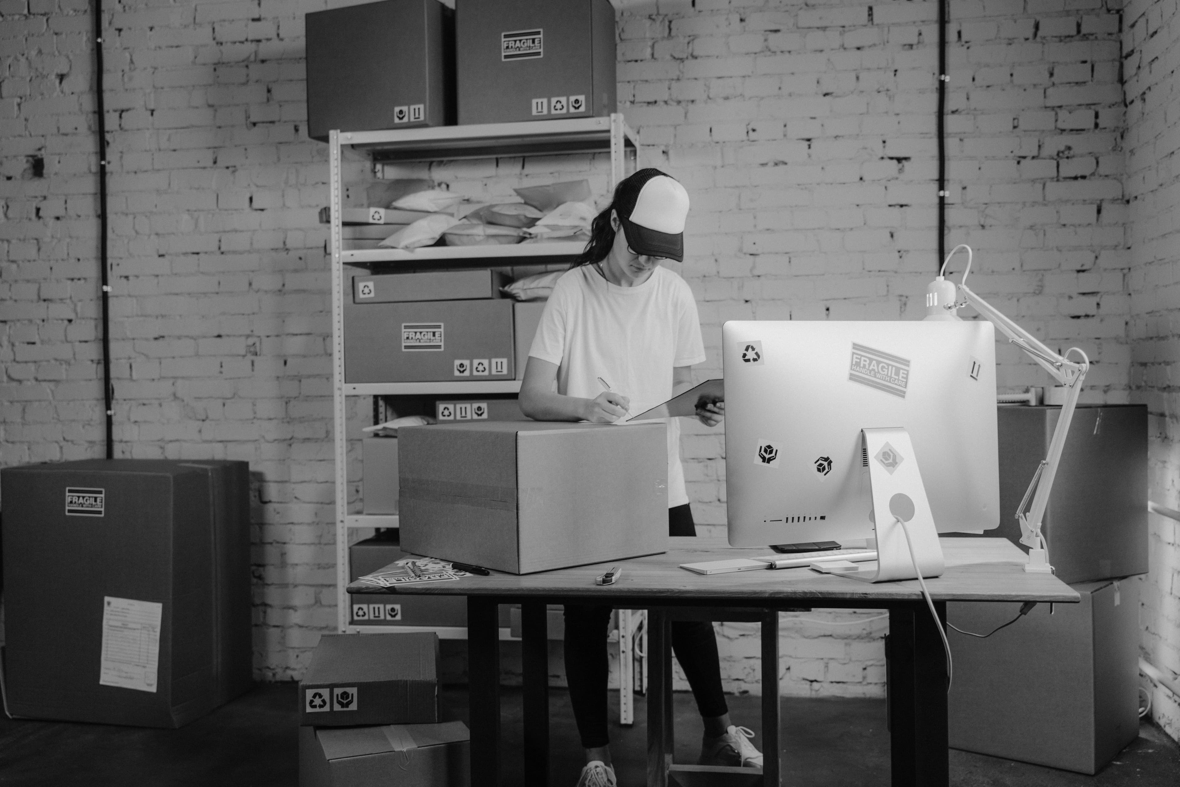 Warehouse fulfillment center with workers packing Shopify orders on conveyor belt